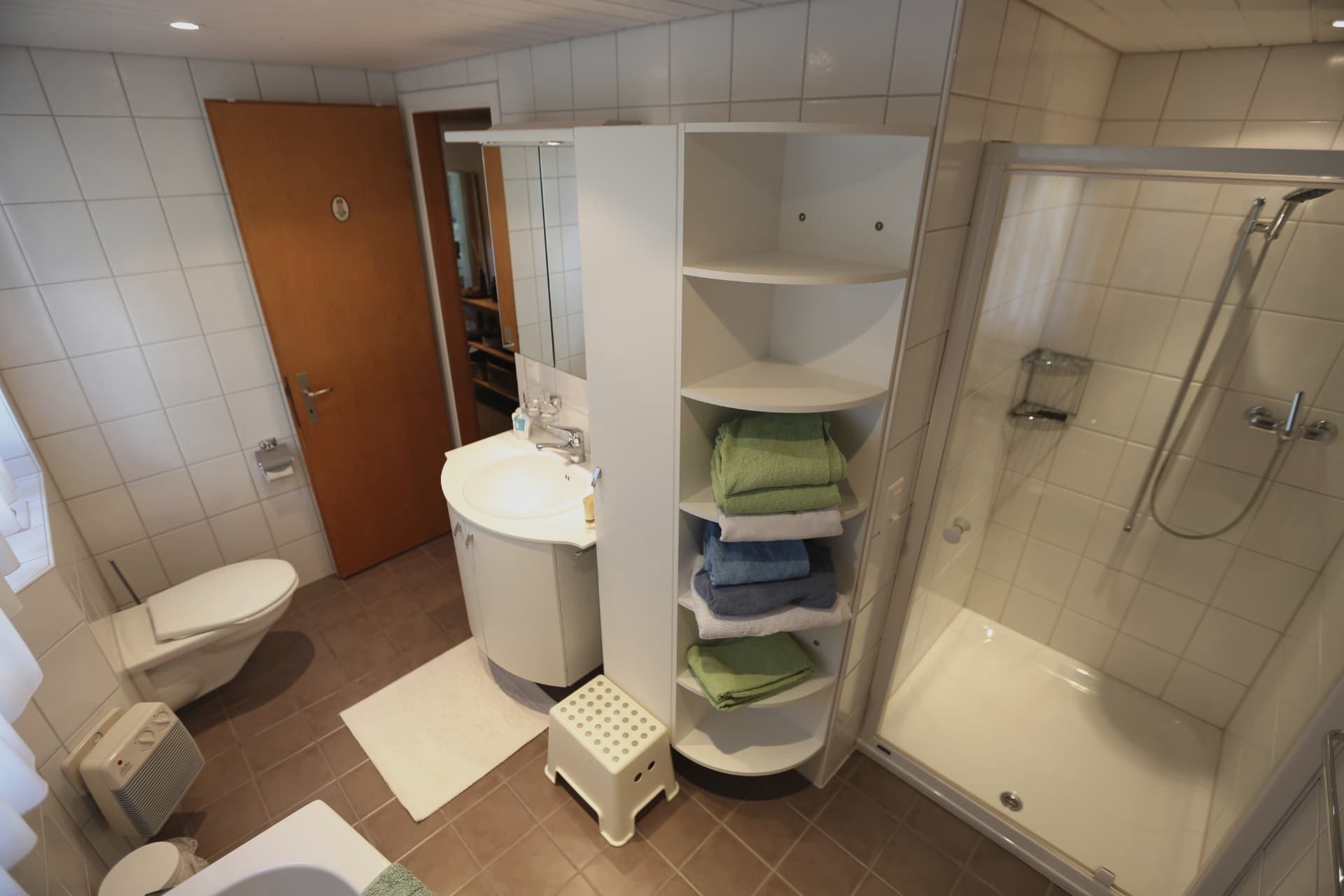 Zweites Badezimmer im Chalet Nördli mit Dusche, Waschbecken und weissen Fliesen