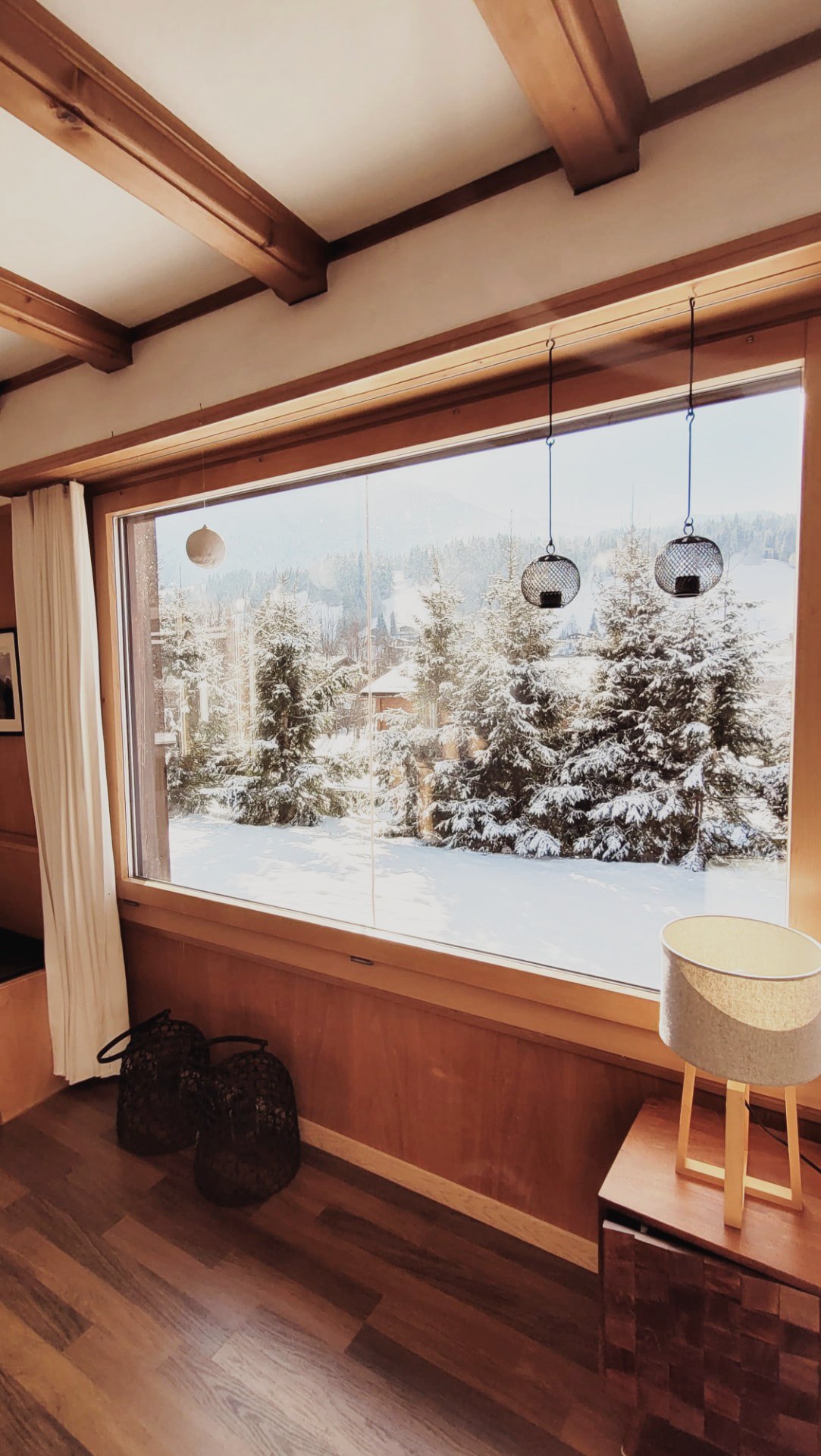 Grosses Fenster im Chalet Nördli mit Blick auf Schnee, Tannen und die Berge von Sörenberg
