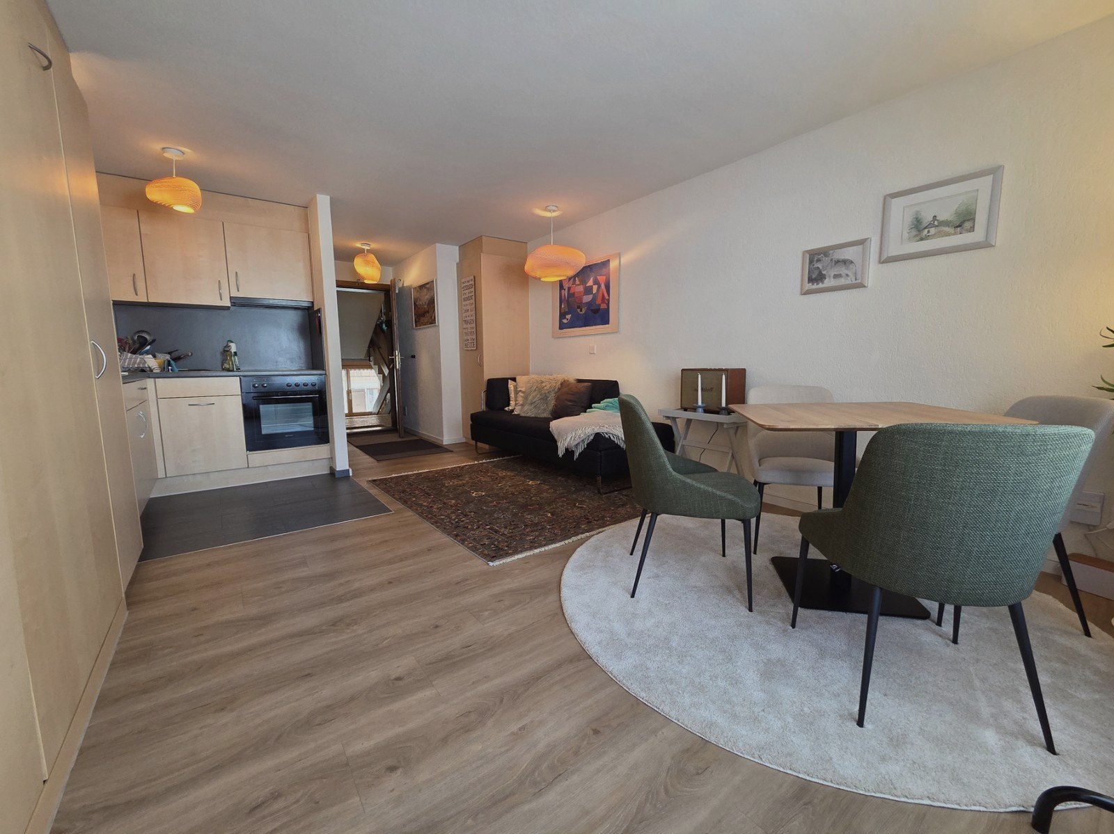 Offene Wohnküche des Studios in Saas-Fee mit hellem Holz, Sitzbank und Essbereich